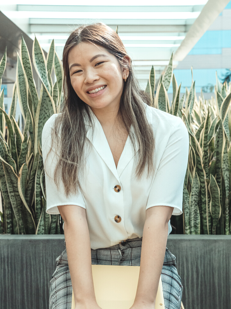 Smiling Woman Wearing a White Top and Plaid Skirt